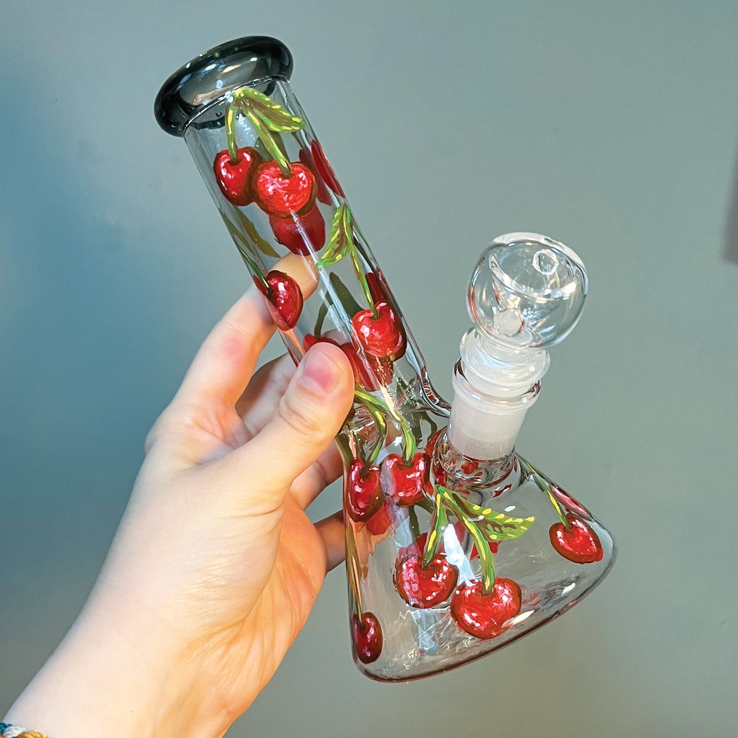 Same bong as before but being held by a hand