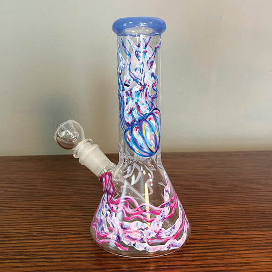 This is another angle of the bong. In this side there is a blue jelly fish going upside down with accents of pink, purple, and yellow. At the bottom there is a sideways pink jellyfish with accents of purple and blue.