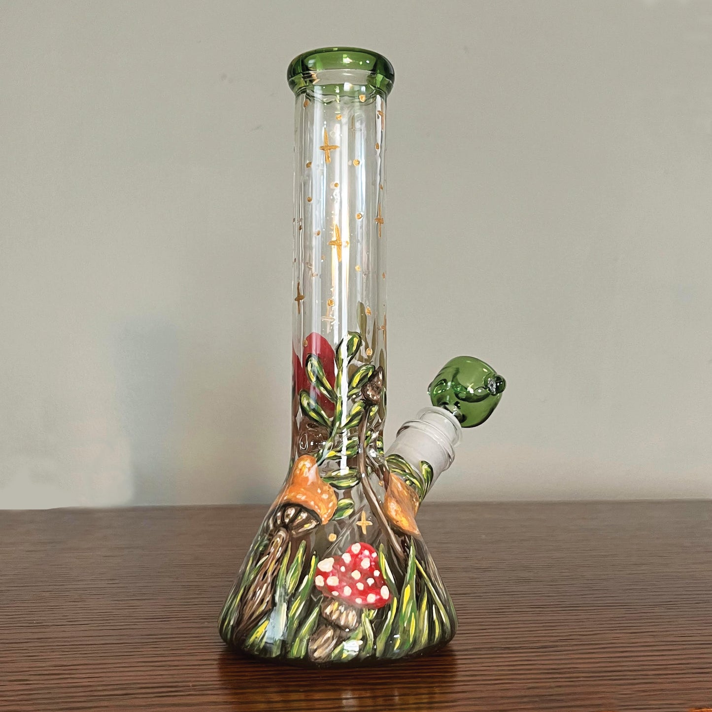 This is the back of the bong. There is a taller orange mushroom next to a red one with white dots.